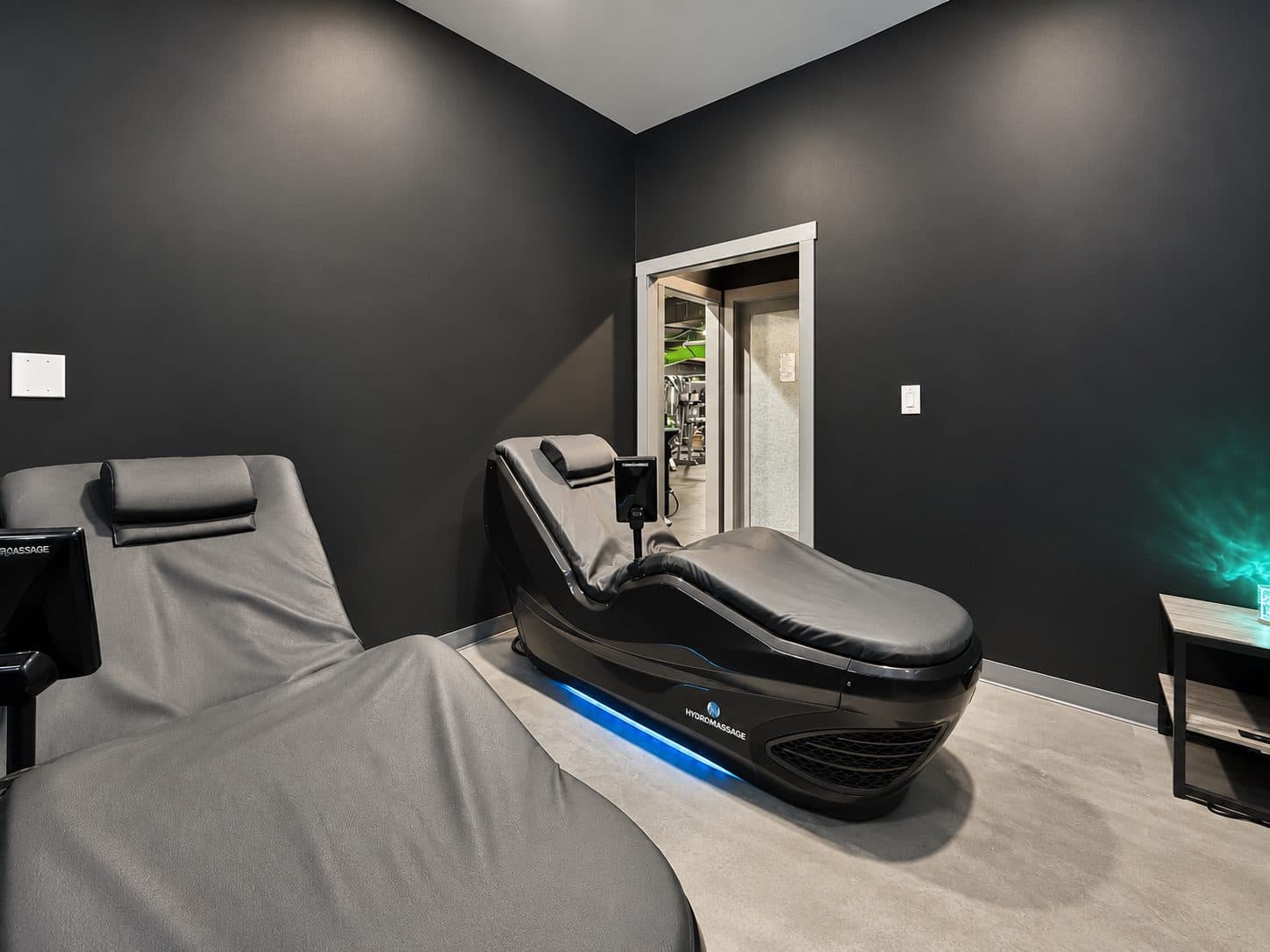 Two hydromassage beds in the dimly lit recovery room at TNU Fitness